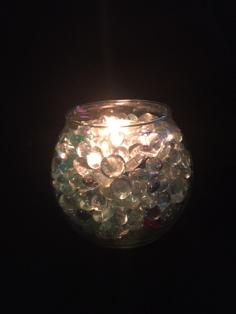 glass marbles in candle on black